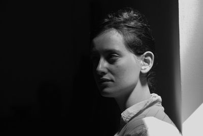 Close-up of young woman standing against wall