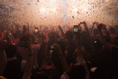 Group of people using mobile phones at music concert