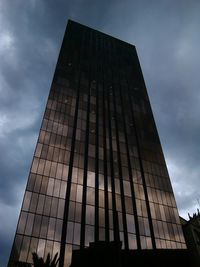 Low angle view of modern building against cloudy sky