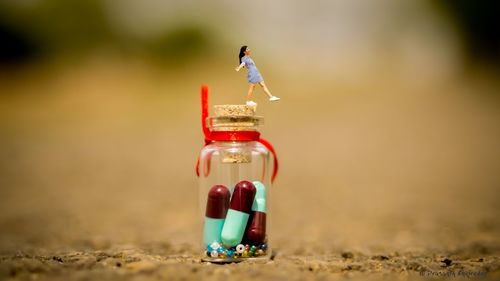 Close-up of toy bottle on sand