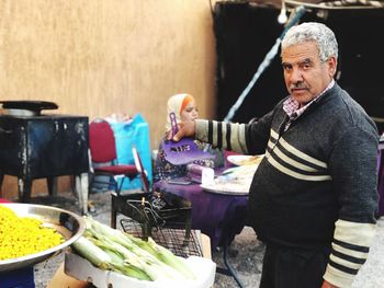 Midsection of man having food at market stall