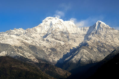 Scenic view of snowcapped mountains against blue sky