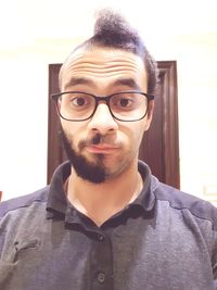 Portrait of young man wearing eyeglasses at home