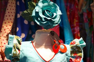 Close-up of artificial turquoise flower on mannequin in store