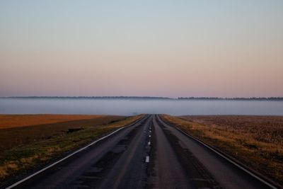 Road amidst landscape against sky during sunset