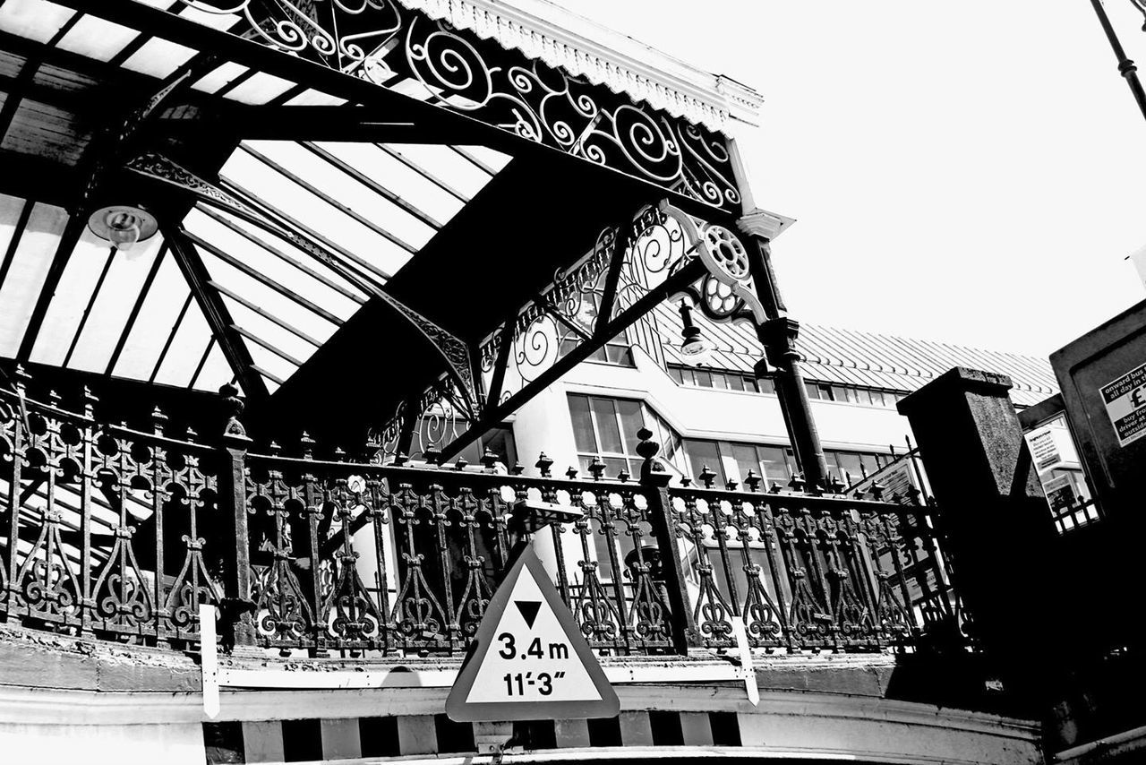 architecture, built structure, building exterior, text, low angle view, western script, communication, railing, building, window, day, clear sky, city, sky, graffiti, non-western script, outdoors, no people, sign, residential building