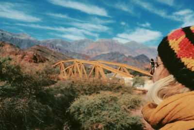 Portrait of woman on bridge against mountains