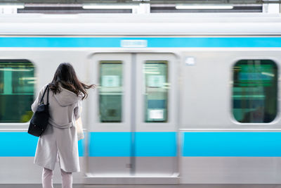 Rear view of woman on train at railroad station