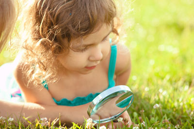 Close-up of cute girl lying on field