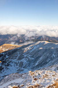 Aerial view of snowcapped mountains against sky