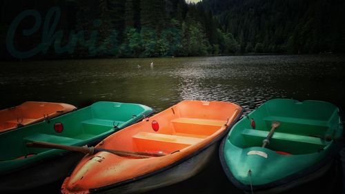 Boats moored on lake against sky