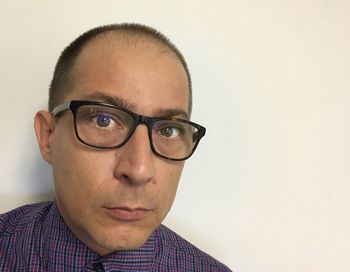 Portrait of man wearing eyeglasses against white background