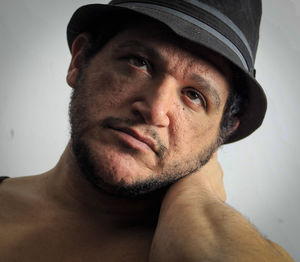 Portrait of young man wearing hat against gray background