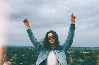 Portrait of young woman standing on land against the sky