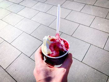 Close-up of hand holding ice cream on floor