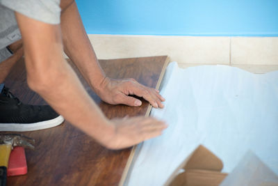 Low section of man working on table at home