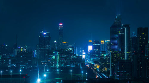 Illuminated buildings in city against sky at night