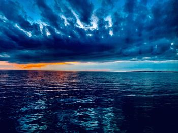 Scenic view of sea against dramatic sky during sunset