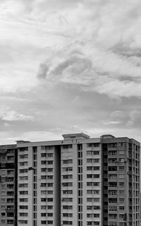 Low angle view of buildings against cloudy sky