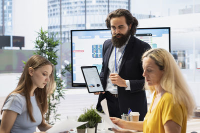 Young woman using mobile phone while sitting on table