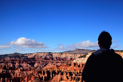 Rear view of man standing by cedar breaks national monument against sky