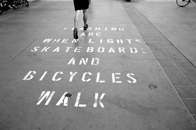 Low section of man with text on road