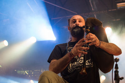 Low angle view of man holding camera at night