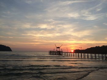 Pier on sea at sunset