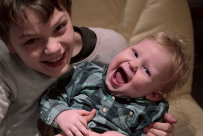 Portrait of happy boy with baby