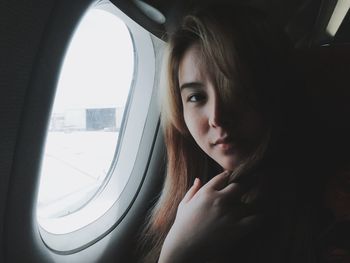 Portrait of woman looking through airplane window