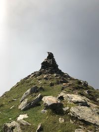 Low angle view of rocks on mountain against sky