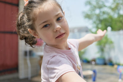 Cute young girl playing in the backyard on a sunny day