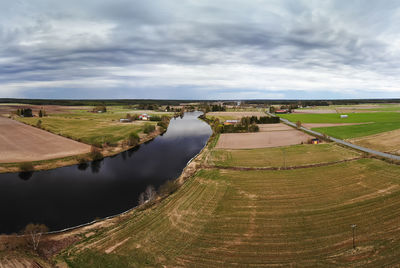 A dramatic cloud formation over the river and fields at the rural finland.