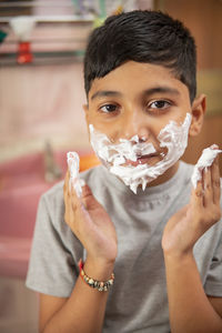 Close-up portrait of boy holding camera