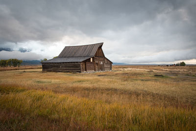 Abandoned house on field against sky