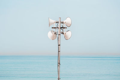 Speaker by sea against clear sky