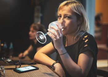 Portrait of woman drinking wine at restaurant