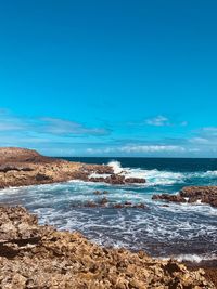 Scenic view of sea against blue sky