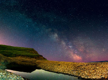 Rock formations at compton bay against milky way