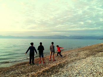 Rear view of people standing on beach