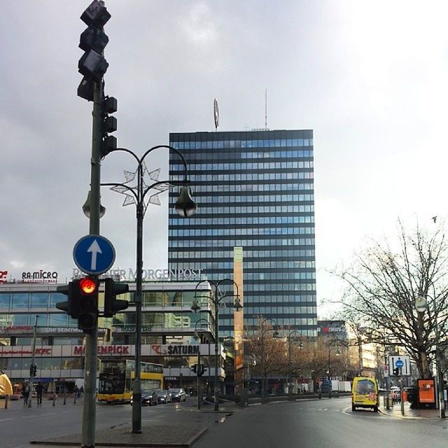 building exterior, architecture, car, built structure, city, transportation, land vehicle, street, mode of transport, road, street light, sky, city life, city street, building, incidental people, road signal, office building, traffic, road sign