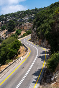 Road leading towards mountain against sky