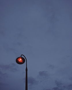 Low angle view of illuminated lighting equipment against sky