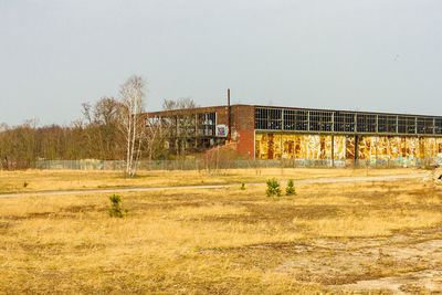 Abandoned building on field against clear sky