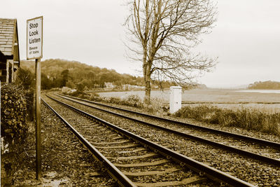 Railroad tracks by trees against sky