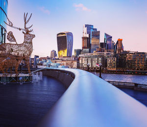 Bridge over river in city against sky