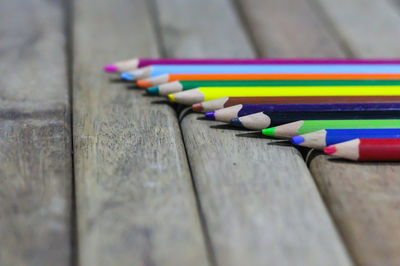 Close-up of colored pencils on wooden table