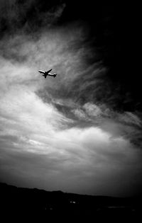 Low angle view of silhouette airplane against sky
