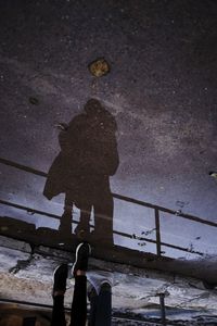 Low section of woman standing on wet street