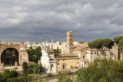 Buildings in city against cloudy sky